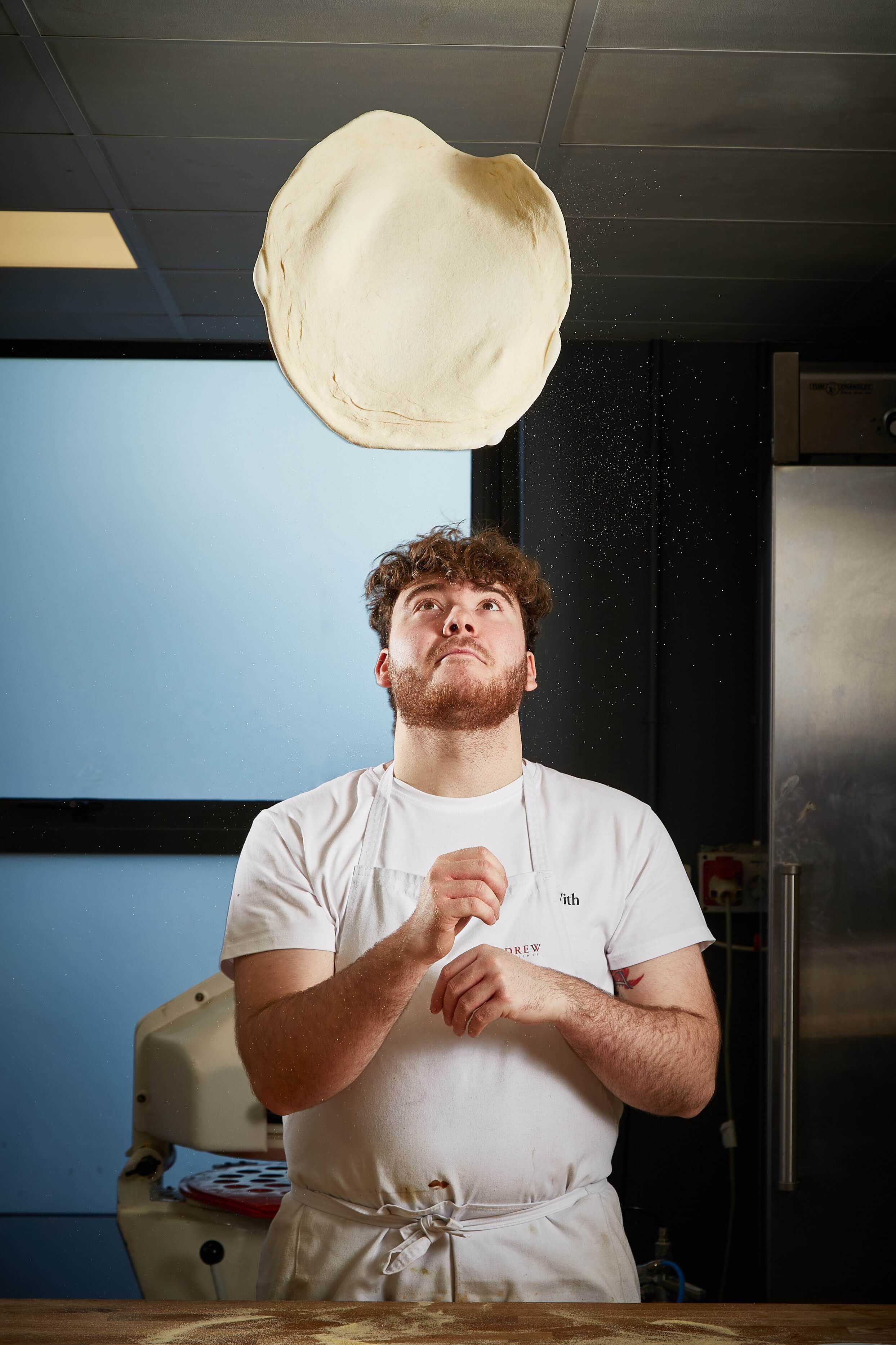 Man throwing pizza dough into the air